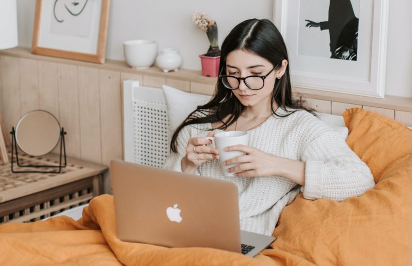 woman-having-coffee-and-using-laptop-in-bed